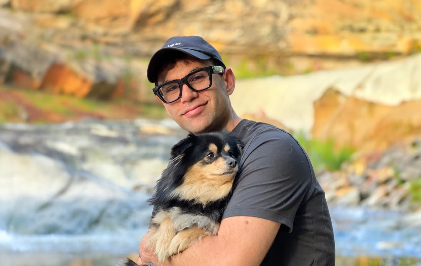 Jacob Ramos holding his dog by a waterfall