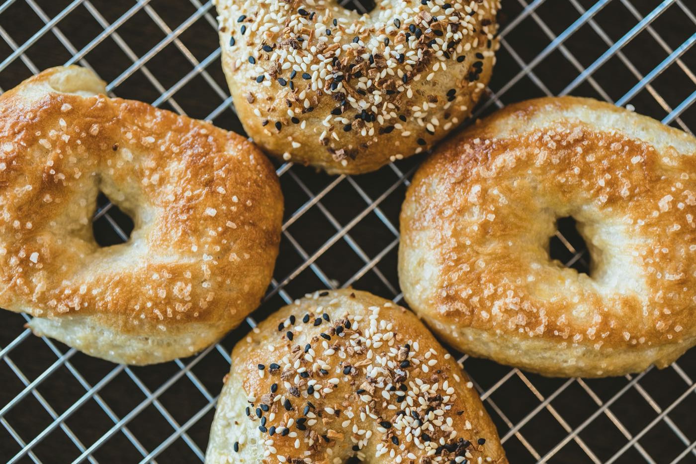 Sesame and everything bagels on a cooling rack
