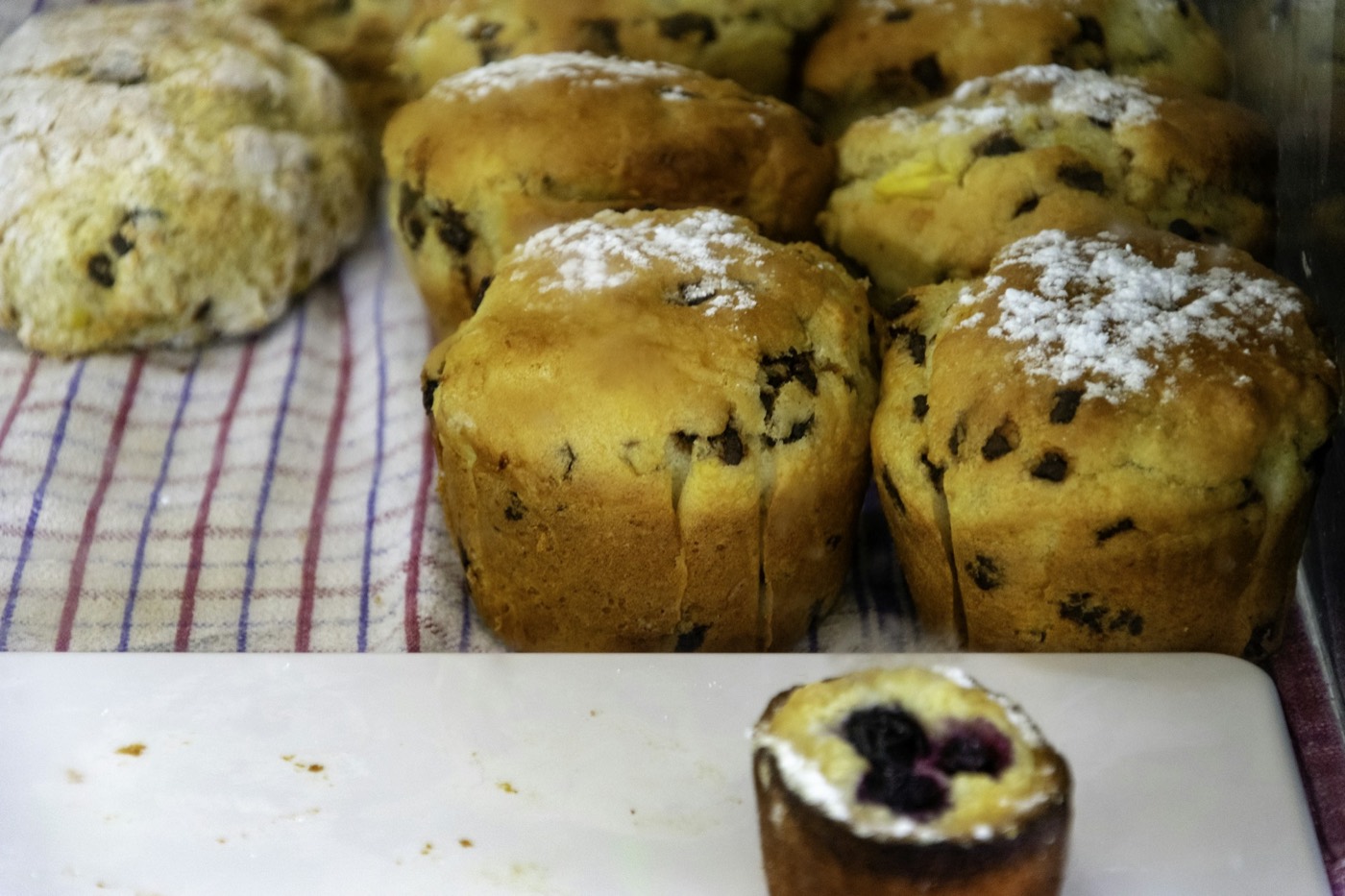 Sugar-topped muffins on a striped cloth in a pastry case