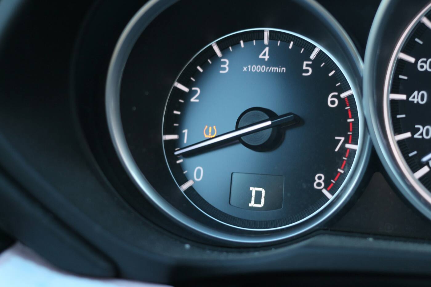 A dashboard gauge with the amber tire pressure warning light on